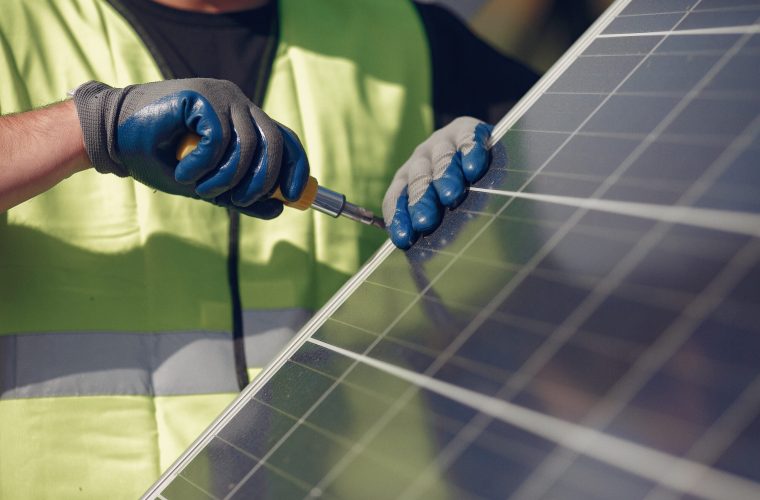 Engineer in a white helmet. Man near solar panel.
